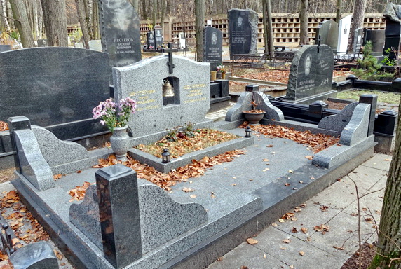 Широкий памятник из серого камня с колоколом посередине